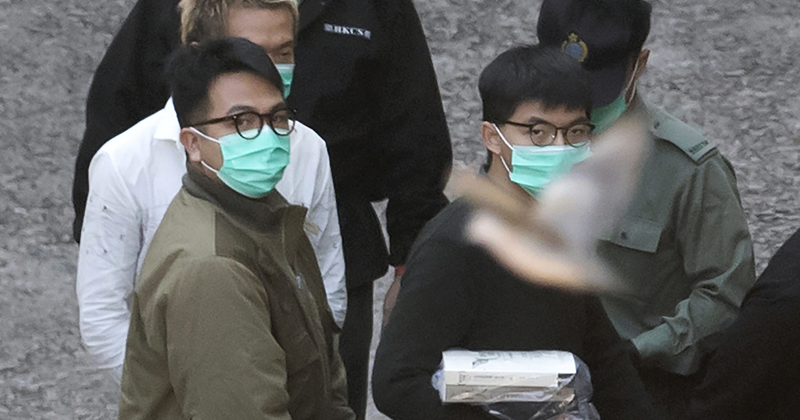Pro-democracy activists Joshua Wong, right, and Ivan Lam are escorted into a prison van before appearing in a court in Hong Kong on Dec. 2, 2020.