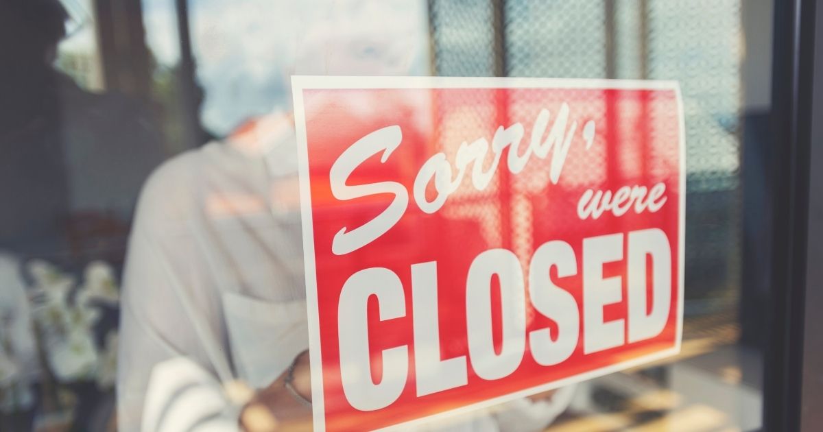 A woman posts a sign in a window in this stock image.