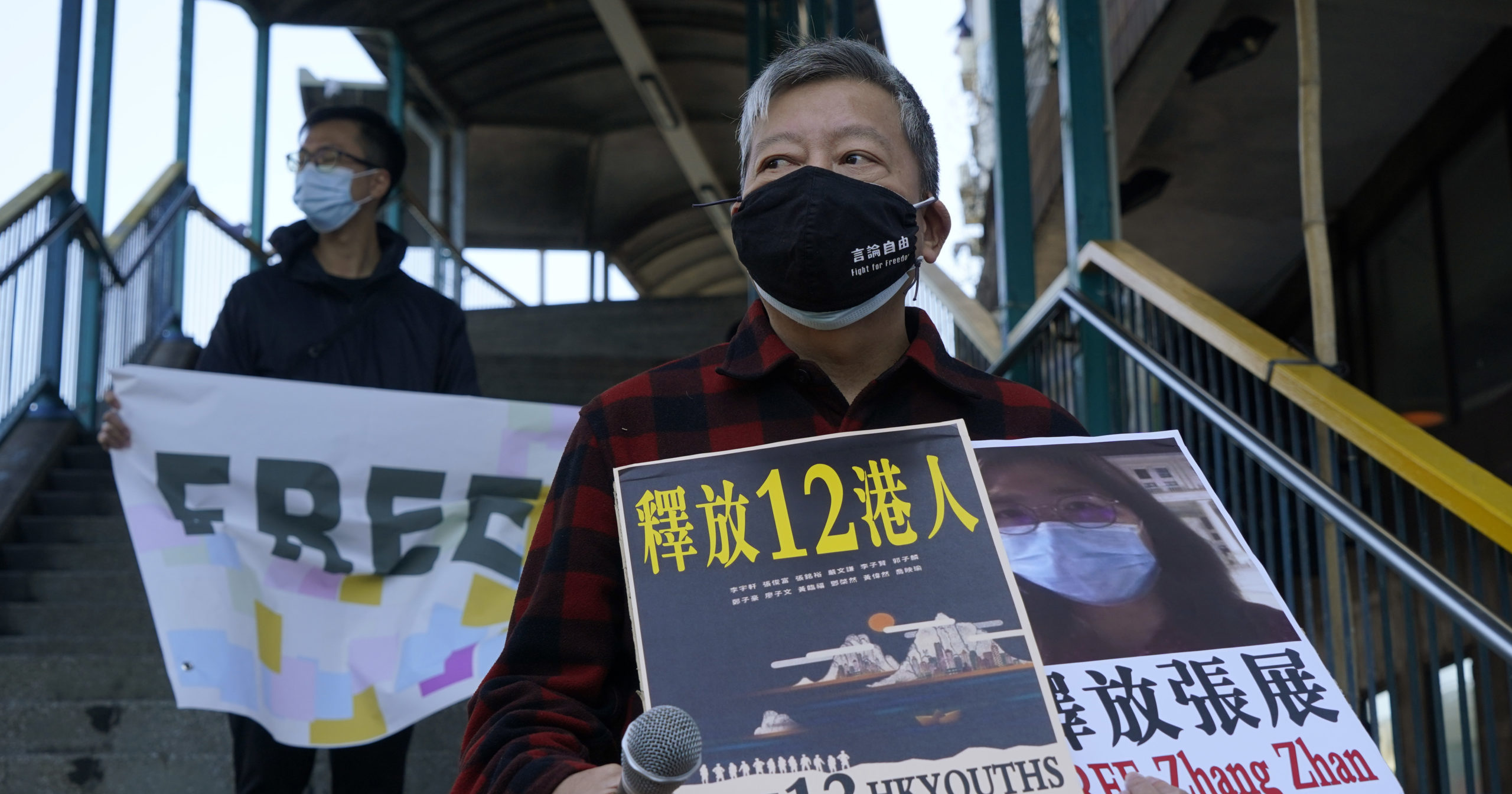 Pro-democracy activists hold placards as they march to the Chinese central government's liaison office in Hong Kong on Dec. 28, 2020.