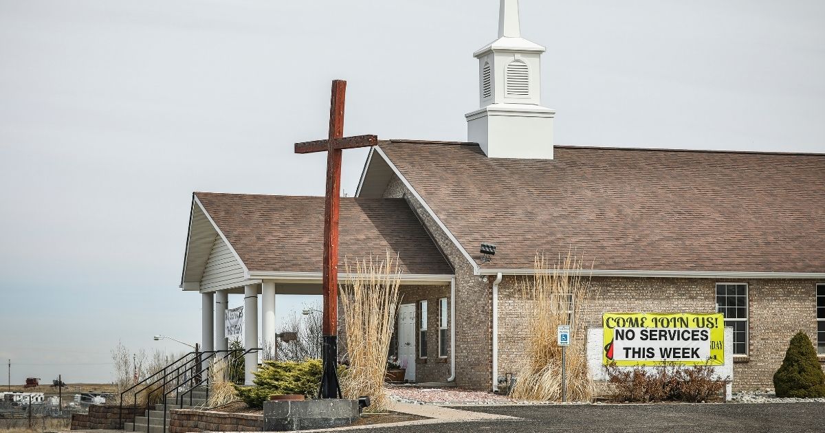 A sign reading "No services this week" hangs outside First Baptist Church on April 5, 2020, in Hudson, Colorado.