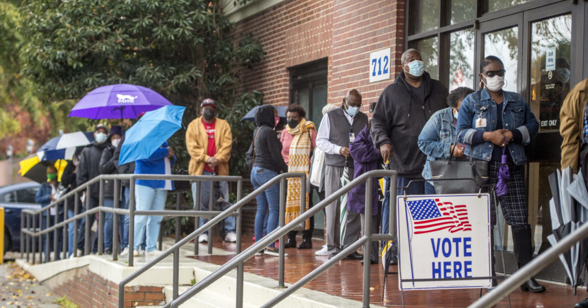people wait in line on the first day of advance voting for Georgia's Senate runoff election