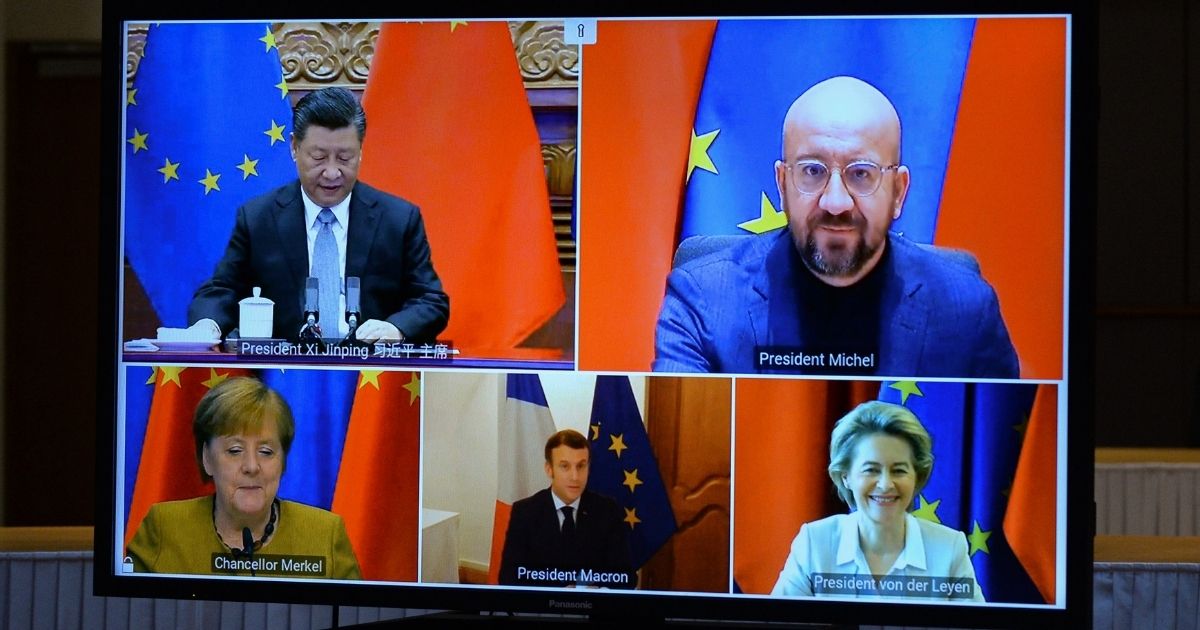European Commission President Ursula von der Leyen, European Council President Charles Michel, German Chancellor Angela Merkel, French President Emmanuel Macron and Chinese President Xi Jinping are seen on a screen during a video conference to approve an investment pact between China and the European Union on Dec. 30, 2020, in Brussels, Belgium.