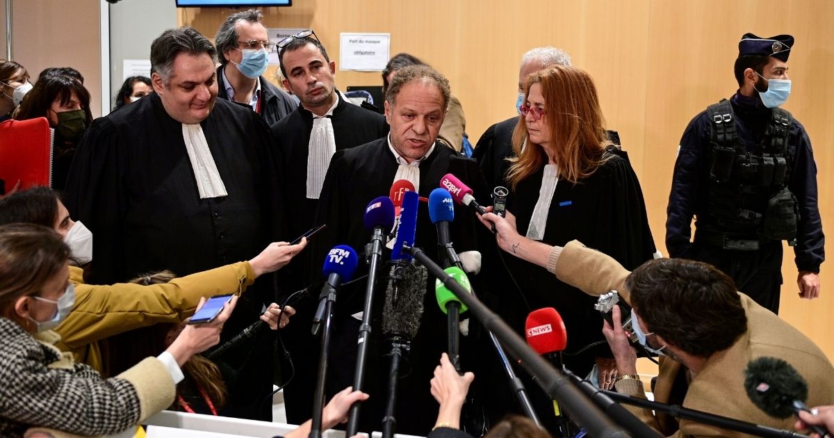 Lawyer Mehana Mouhou, center, talks to the media at a Paris courthouse on Dec. 16, 2020, after the sentencing hearing in the trial of 14 people suspected of acting as accomplices in the Charlie Hebdo jihadist killings.