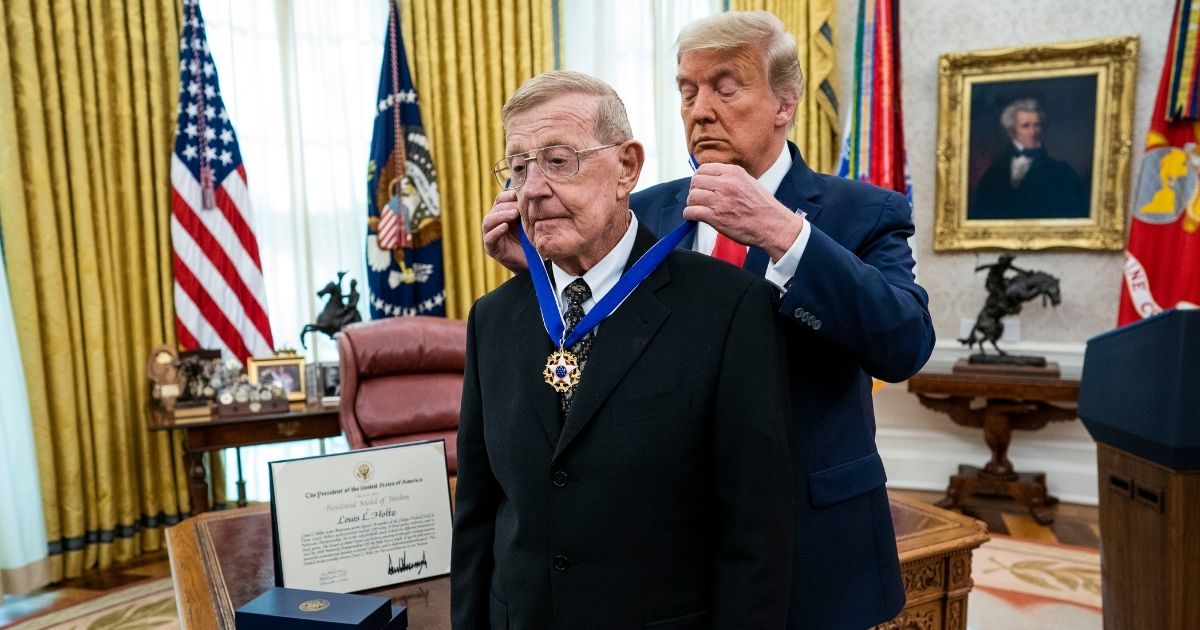 President Donald Trump presents the Medal of Freedom to former college football coach Lou Holtz in the Oval Office of the White House on Dec. 3, 2020, in Washington, D.C.