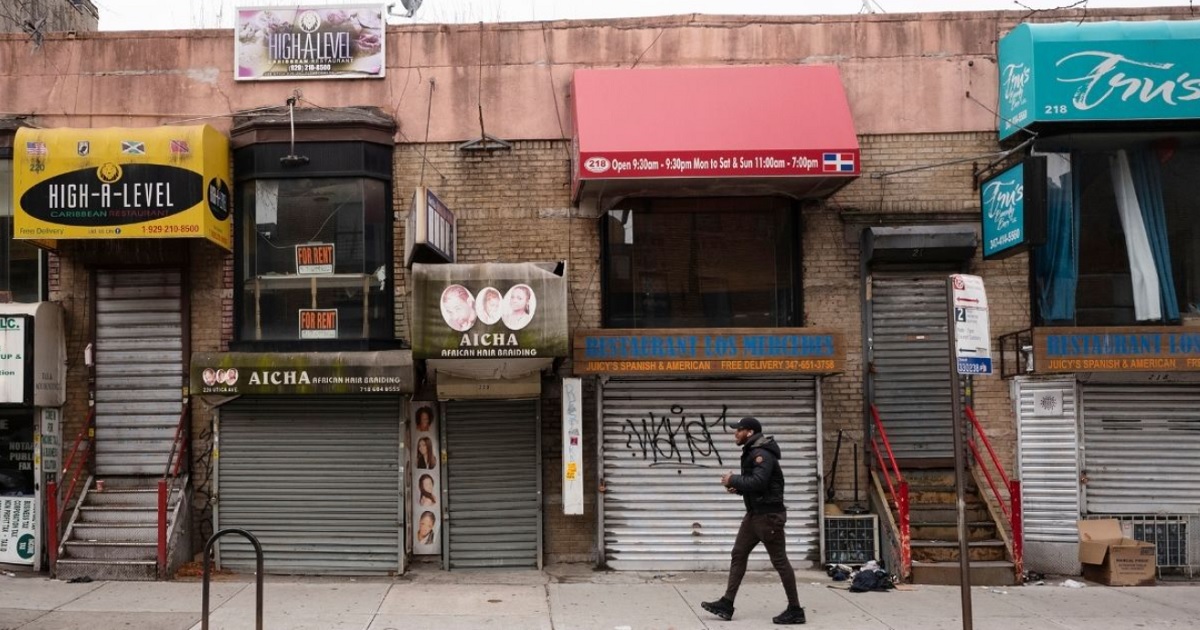 In this April 8, 2020, file photo, a pedestrian strolls past small businesses that are shuttered closed during the coronavirus epidemic in the Crown Heights neighborhood of Brooklyn in New York City.