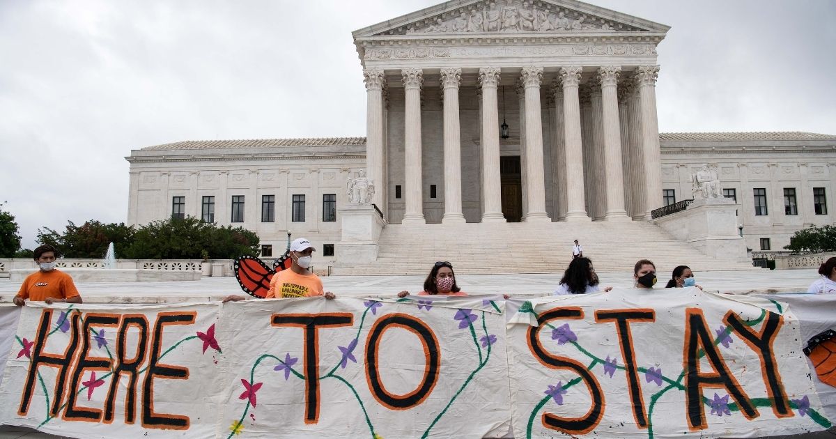 Activists supporting the Deferred Action for Childhood Arrivals program hold a banner in front of the US Supreme Court in Washington, D.C., on June 18, 2020.