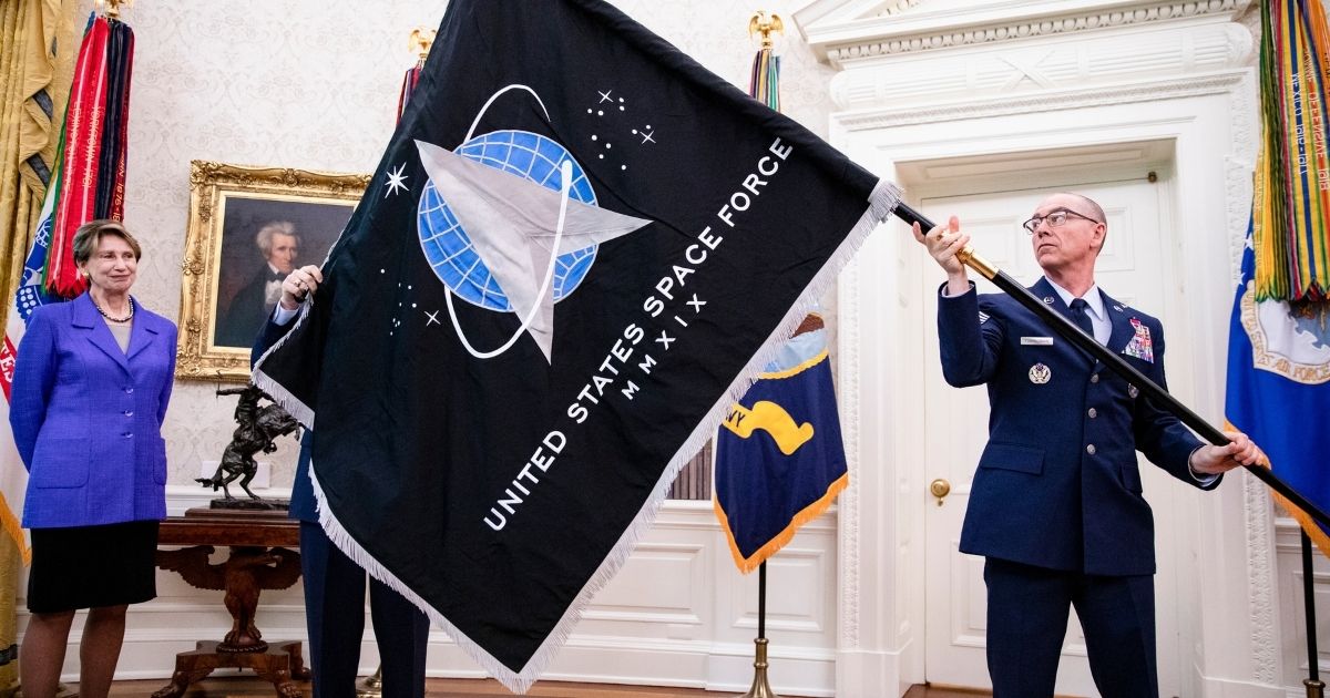 Chief Master Sgt. Roger Towberman and Secretary of the Air Force Barbara Barrett present President Donald Trump with the official flag of the United States Space Force in the Oval Office of the White House in Washington, D.C., on May 15, 2020.