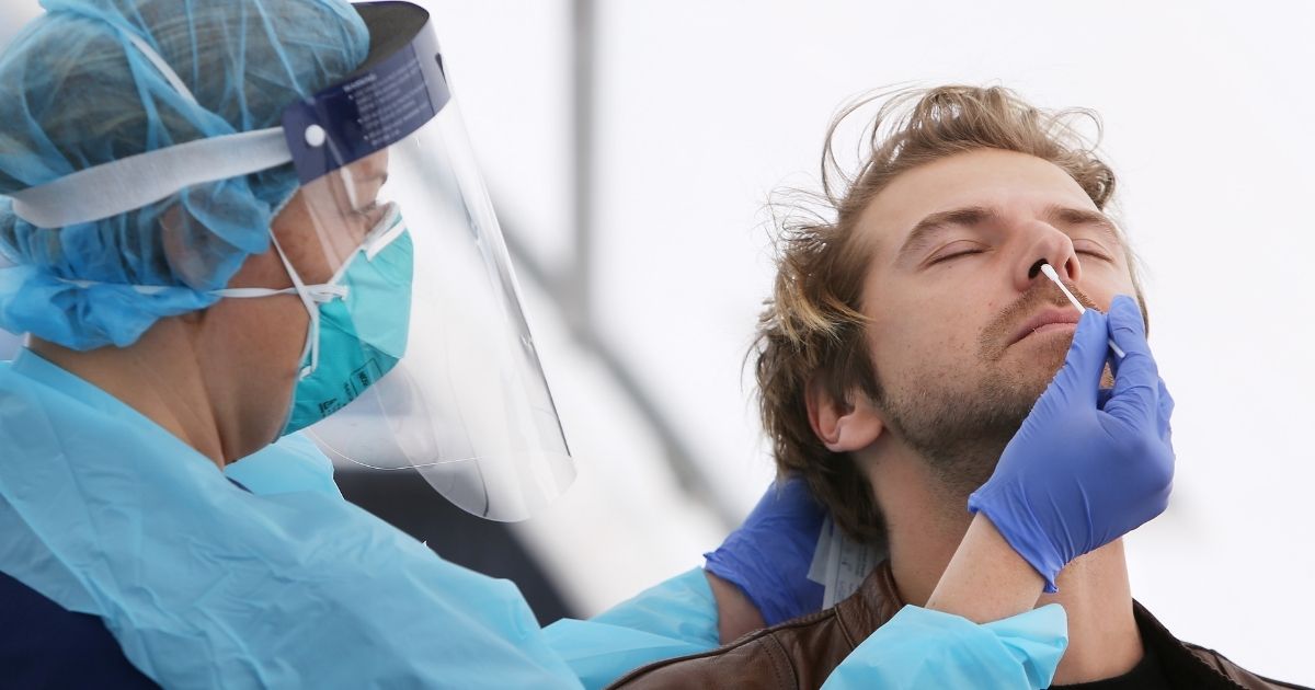 A nurse conducts a COVID-19 test on a man on July 22, 2020, in Sydney, Australia.
