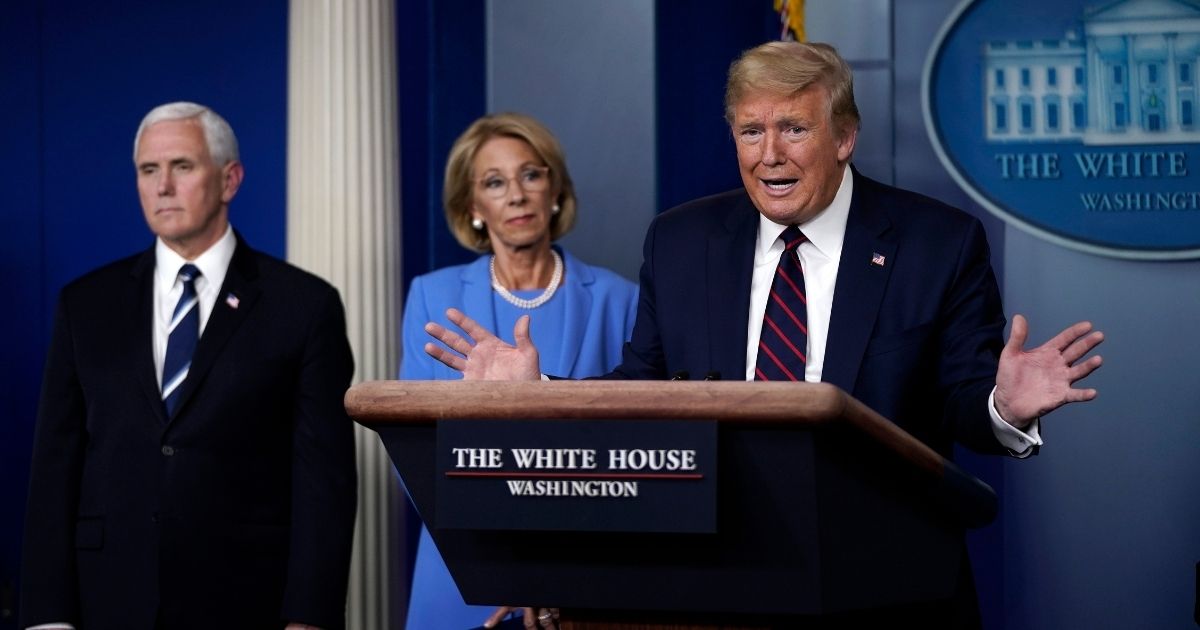 President Donald Trump speaks as Vice President Mike Pence and Secretary of Education Betsy DeVos look on during a briefing at the White House on March 27, 2020, in Washington, D.C.