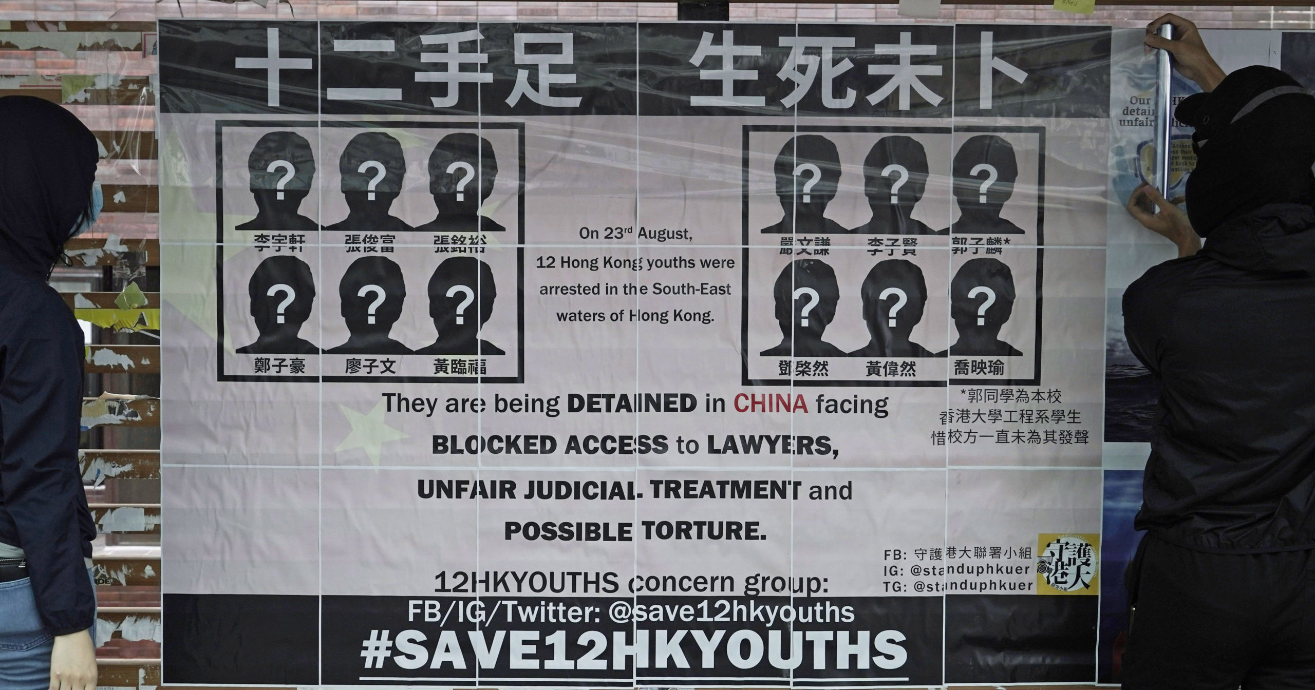 University students put up posters demanding the release of 12 Hong Kong pro-democracy activists detained at sea by Chinese authorities on Sept. 29, 2020.