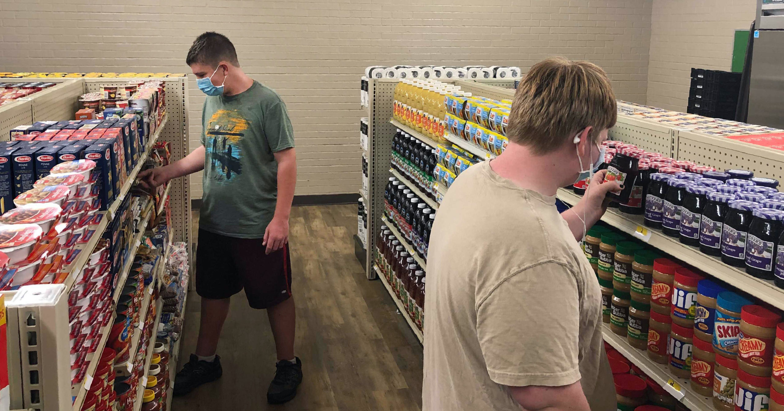 Student Hunter Weertman, 16, left, stocks shelves and takes inventory while working as a manager of the student-led free grocery store at Linda Tutt High School on Nov. 20, 2020, in Sanger, Texas.