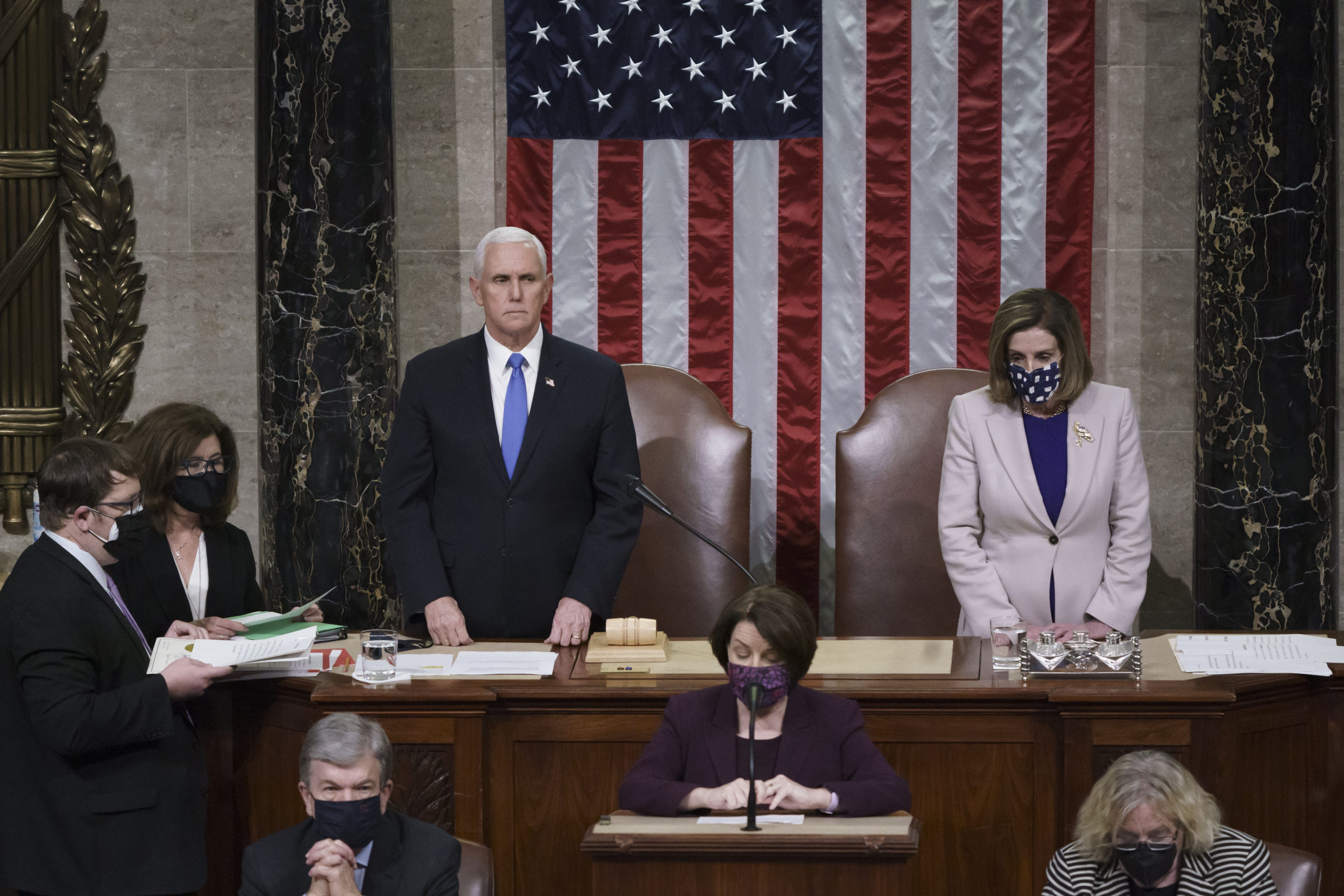 Vice President Mike Pence and House Speaker Nancy Pelosi, D-Calif., read the final certification of Electoral College votes cast in November's presidential election during a joint session of Congress that ended early Thursday.