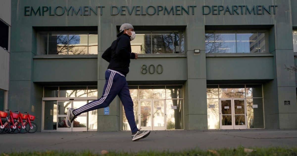 A runner passes the office of the California Employment Development Department in Sacramento, California, on Dec. 18, 2020.
