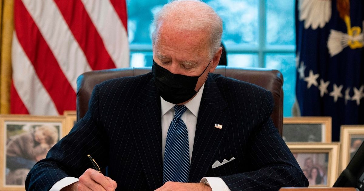 President Joe Biden signs an executive order in the Oval Office of the White House in Washington, D.C., on Monday.