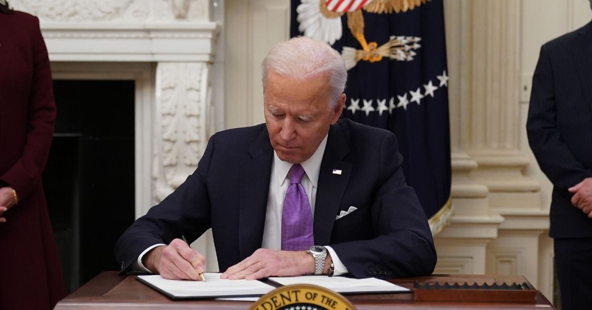 President Joe Biden signs executive orders as part of the Covid-19 response in the State Dining Room of the White House in Washington, D.C., on Thursday.