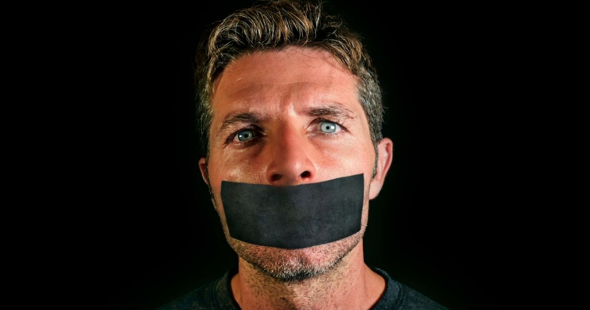 A man with tape over his mouth is pictured in the stock image above.