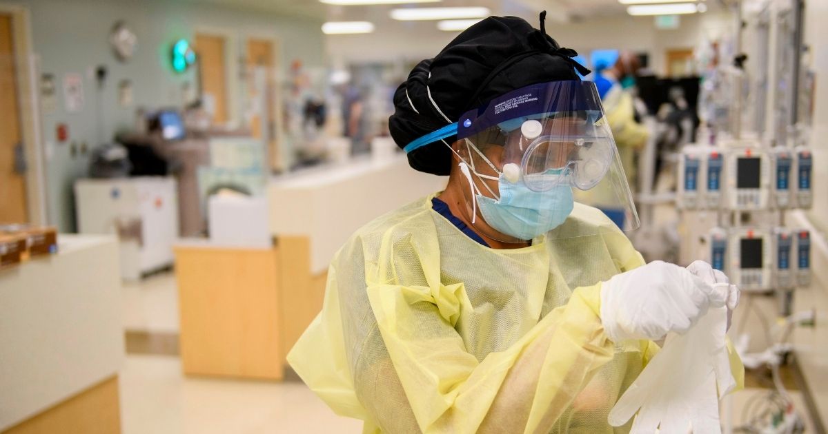 A nurse dons personal protective equipment (PPE) to attend to a patient in a COVID-19 intensive care unit at Martin Luther King Jr. Community Hospital on Jan. 6, 2021, in the Willowbrook neighborhood of Los Angeles.