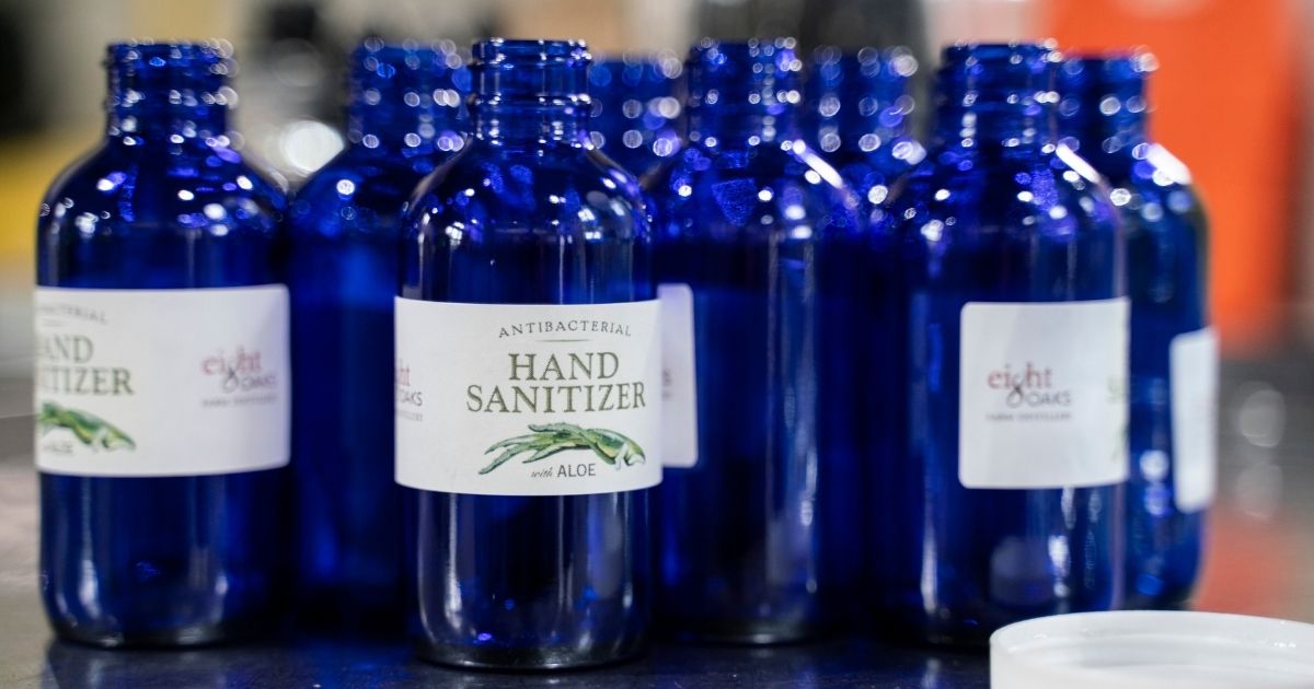 Crew members apply labels to bottles for hand sanitizer at Eight Oaks Farm Distillery in New Tripoli, Pennsylvania, on March 19, 2020.