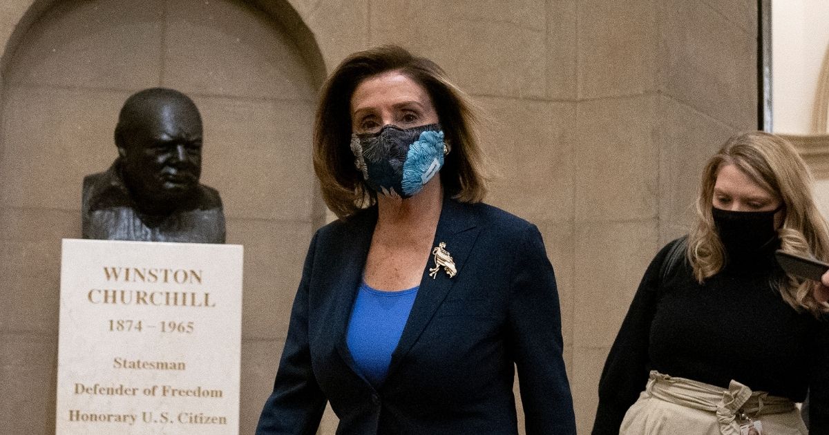 Speaker of the House Nancy Pelosi wears a protective mask while arriving to the U.S. Capitol on Tuesday in Washington, D.C.