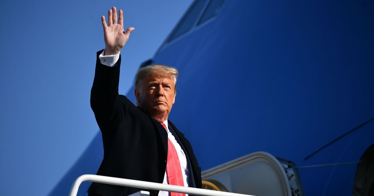 President Donald Trump waves to the media as he makes his way to board Air Force One before departing from Andrews Air Force Base in Maryland on Jan. 12, 2021.