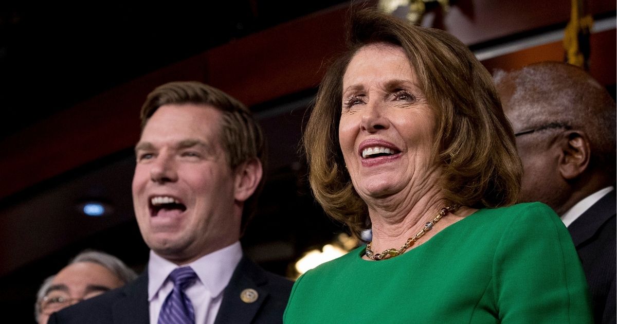 Then-House Minority Leader Nancy Pelosi, right, and California Democratic Rep. Eric Swalwell laugh at a news conference on Capitol Hill in Washington on March 24, 2017.
