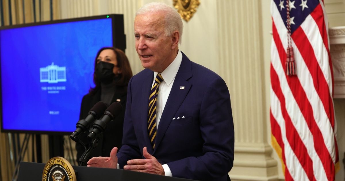 President Joe Biden speaks as Vice President Kamala Harris looks on during an event in the State Dining Room of the White House on Friday in Washington, D.C.