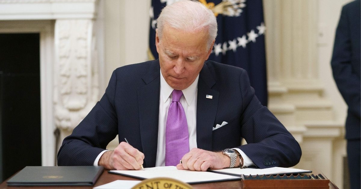 President Joe Biden signs executive orders in the State Dining Room of the White House in Washington on Thursday.