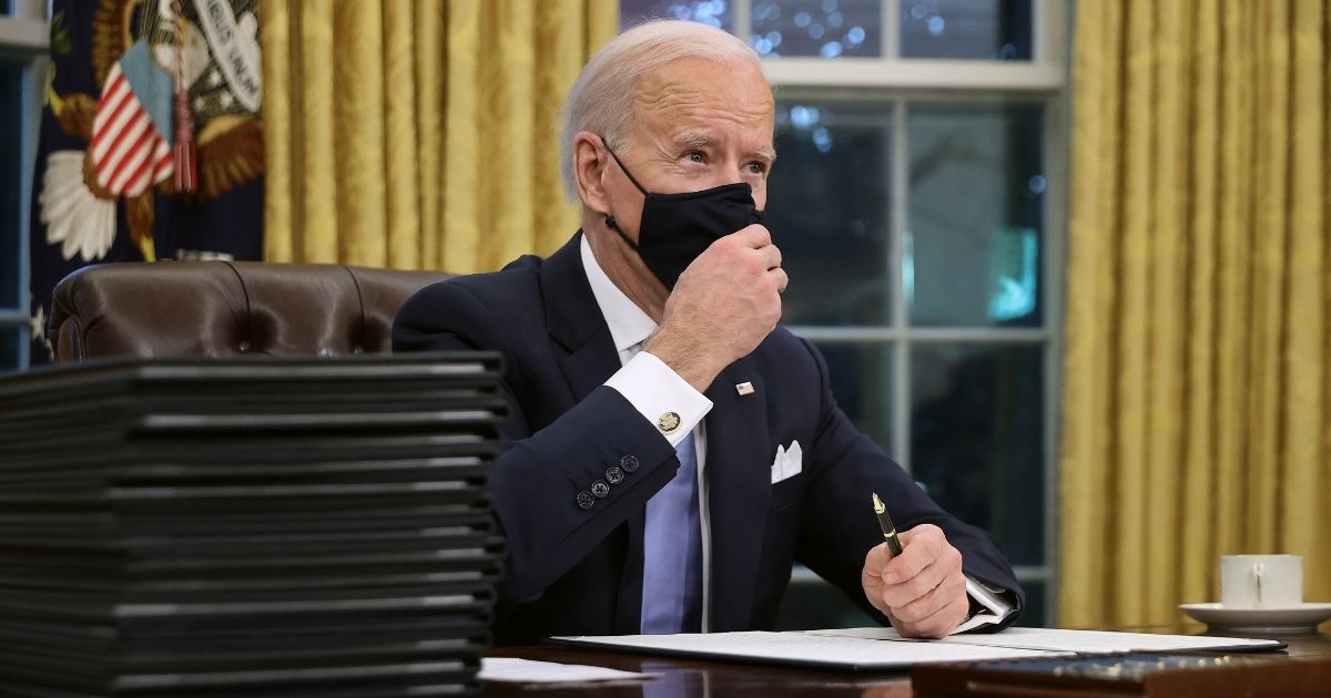 President Joe Biden prepares to sign a series of executive orders at the Resolute Desk in the Oval Office just hours after his inauguration on Wednesday in Washington, D.C.