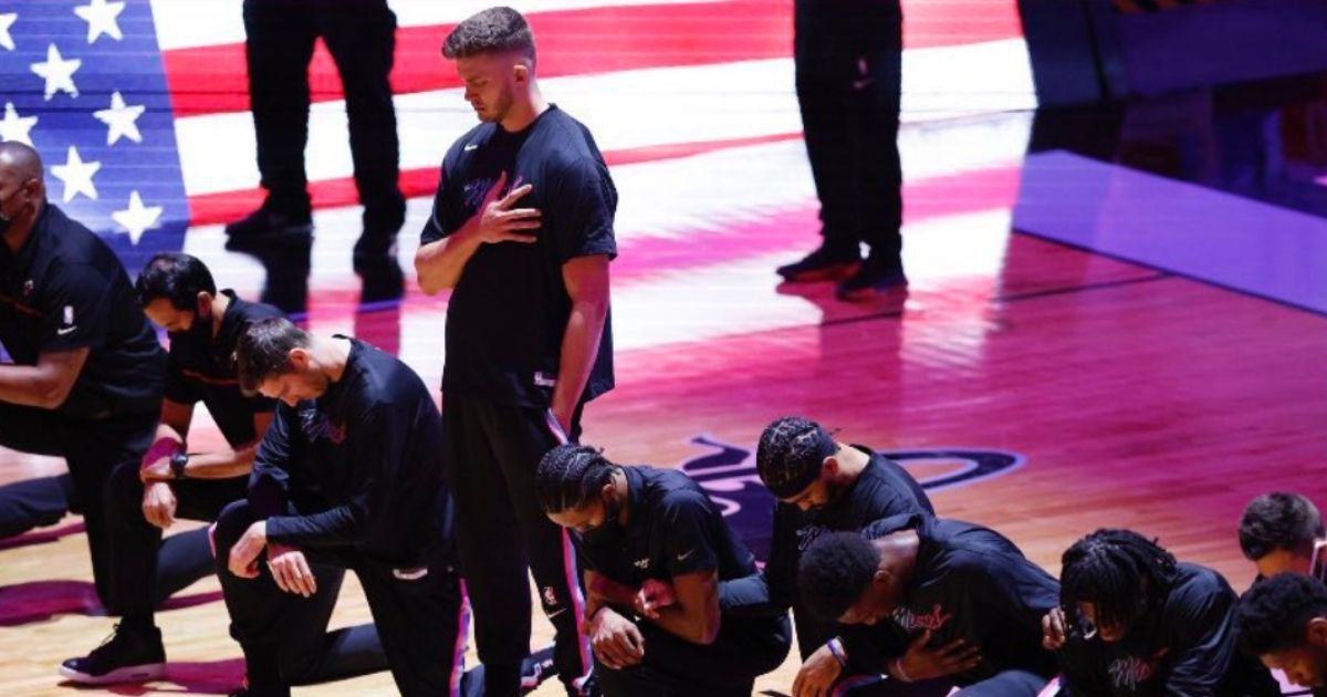 Meyers Leonard of the Miami Heat stands as the rest of the players kneel during the national anthem prior to the start of the game against the Boston Celtics on Wednesday night in Miami.