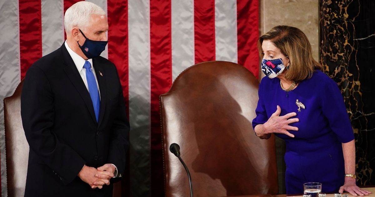 Speaker of the House Nancy Pelosi and Vice President Mike Pence, left, talk as a joint session of the House and Senate convenes to count the Electoral College votes cast in November's election, at the Capitol in Washington on Jan. 6, 2021.