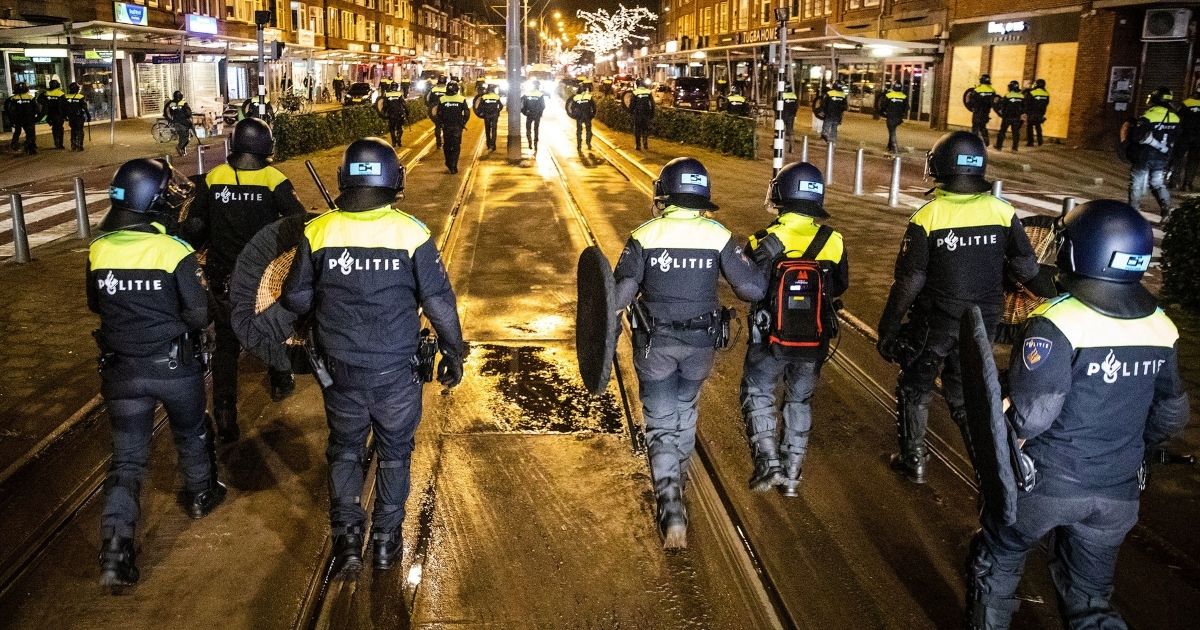 Dutch police officers patrol in the streets of Rotterdam during curfew on Tuesday.