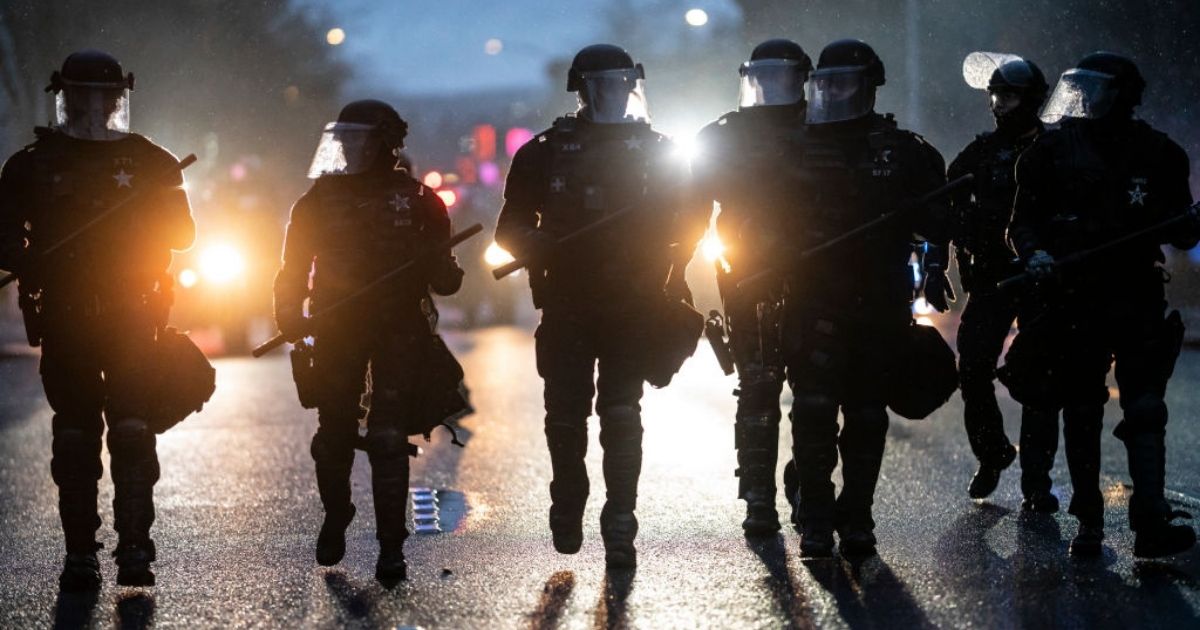 Police disperse demonstrators during a protest against COVID-19 restrictions in Salem, Oregon, on Friday.