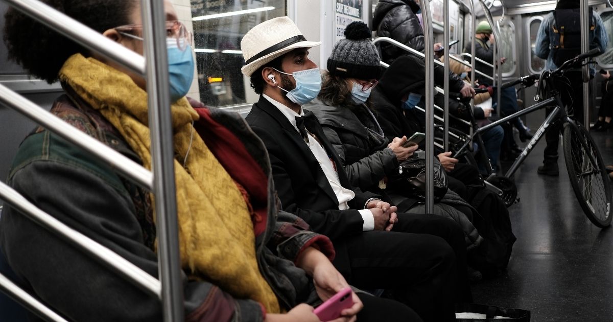 People ride on a subway train while wearing masks at a Brooklyn station on Nov. 18, 2020, in New York City.