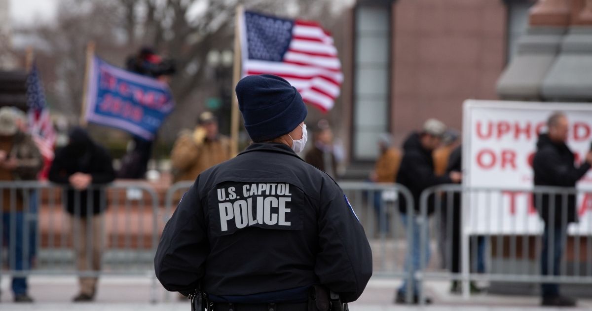 A Capitol Police officer watches supporters as supporters of President Donald Trump gathered Wednesday before a violent incursion into the Capitol.