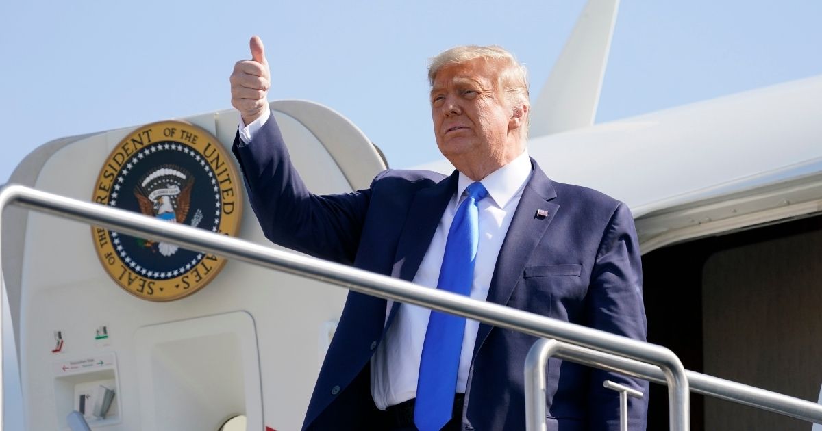 President Donald Trump gives a thumbs up to supporters from the door of Air Force One in a file photo from Oct. 18. Trump plans to leave Washington ahead of President-elect Joe Biden's inauguration, according to The Associated Press.