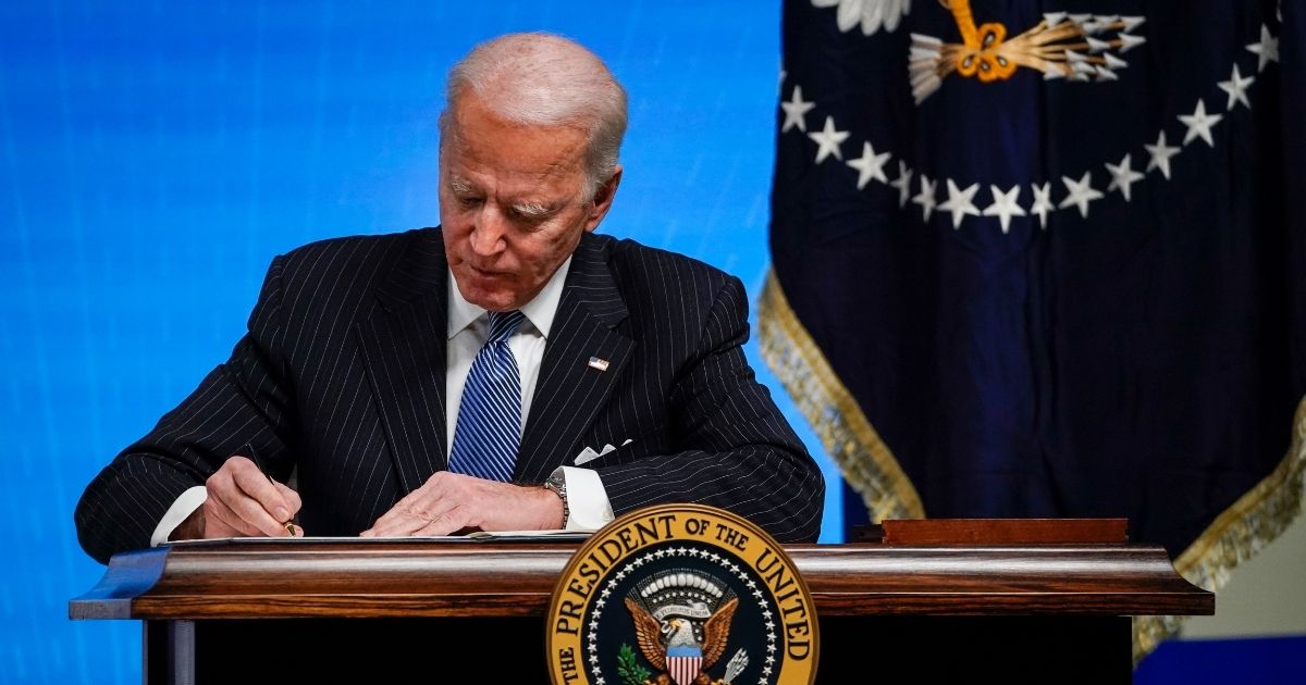 President Joe Biden signs an executive order Monday at the White House.