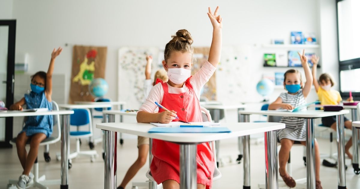 In this stock photo, children raise their hands in a classroom during the pandemic. In January 2021, several states already have introduced school choice policies.