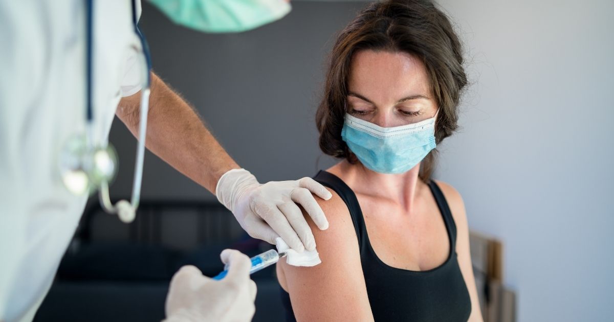 The CDC reports that just because one gets the vaccine, doesn't mean they are immune to COVID-19. The above stock image shows a woman getting vaccinated.