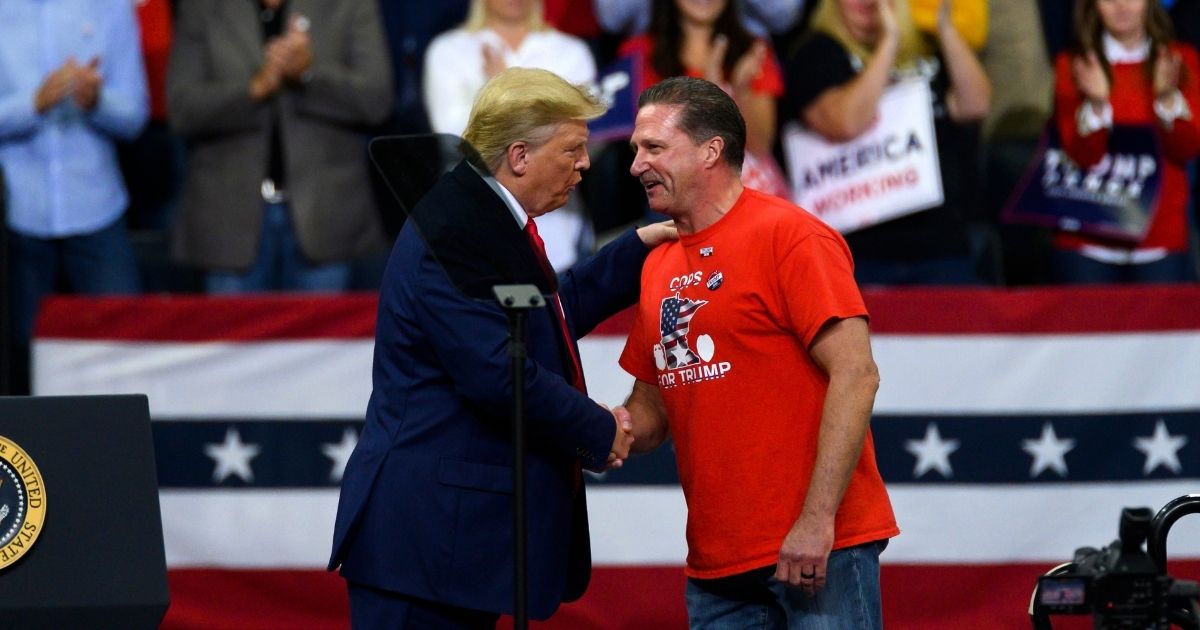 President Donald Trump shakes hands with Minneapolis police union head Bob Kroll during a campaign rally at the Target Center on Oct. 10, 2019, in Minneapolis, Minnesota.
