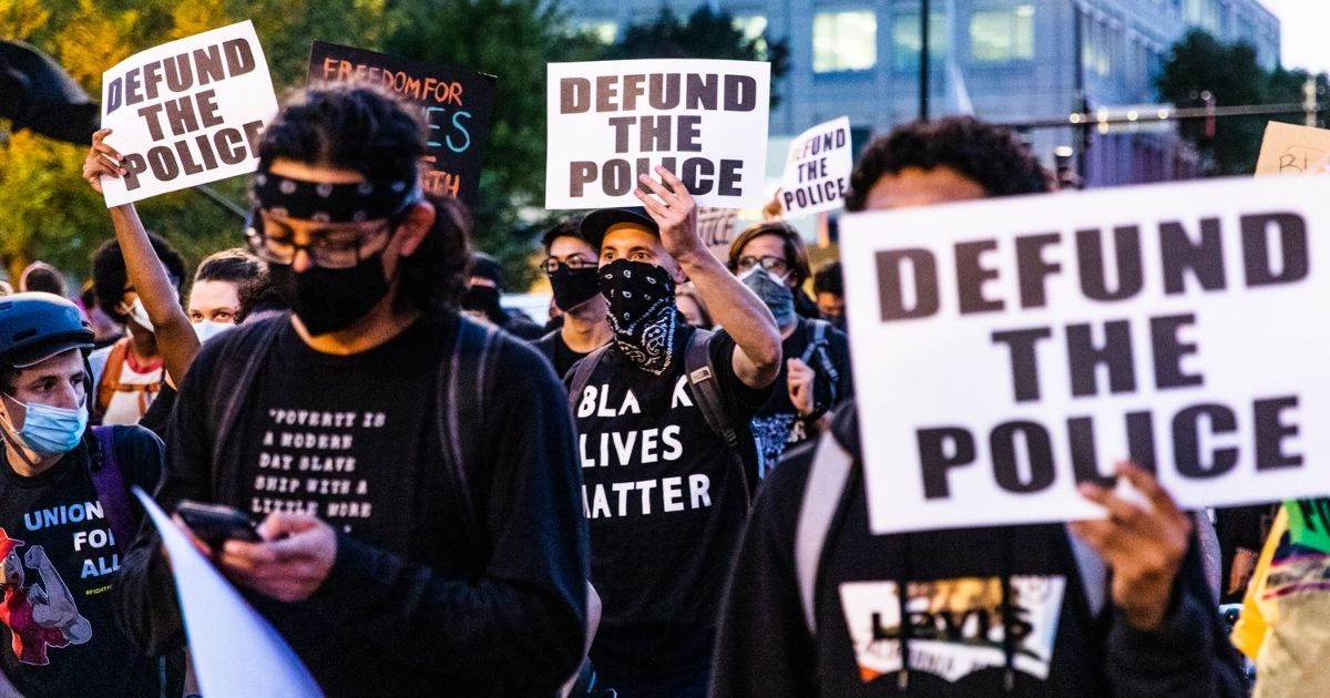 Protesters carry signs in support of defunding the police during a march on Sept. 23, 2020, in Chicago.