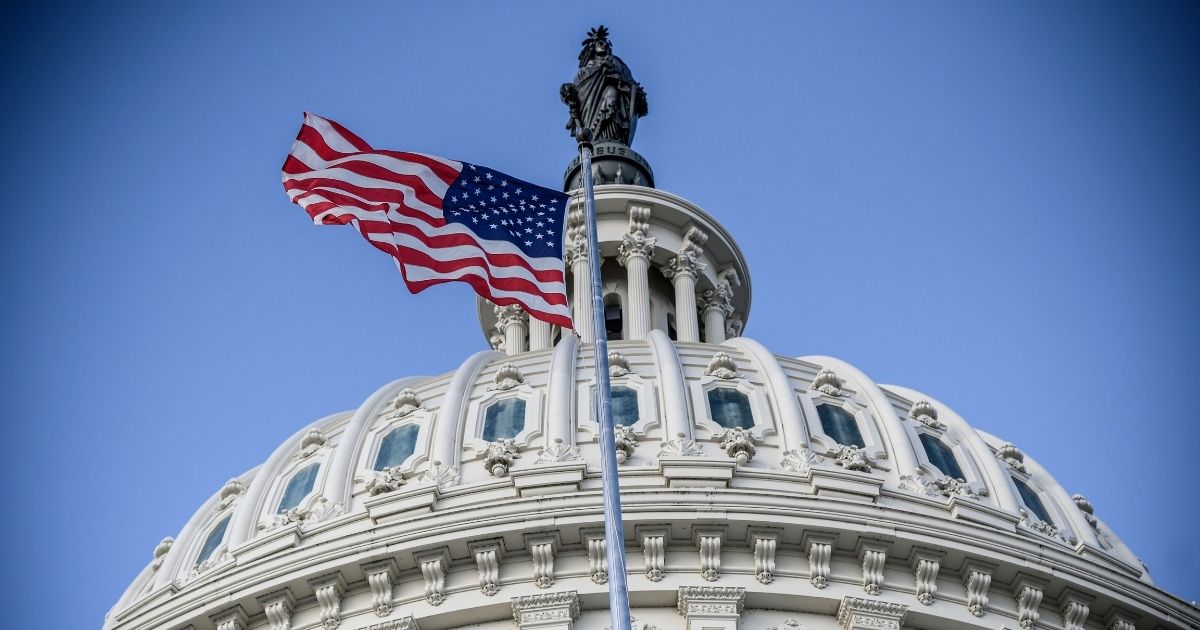 The American flag flies before the US Capitol in the above stock image.