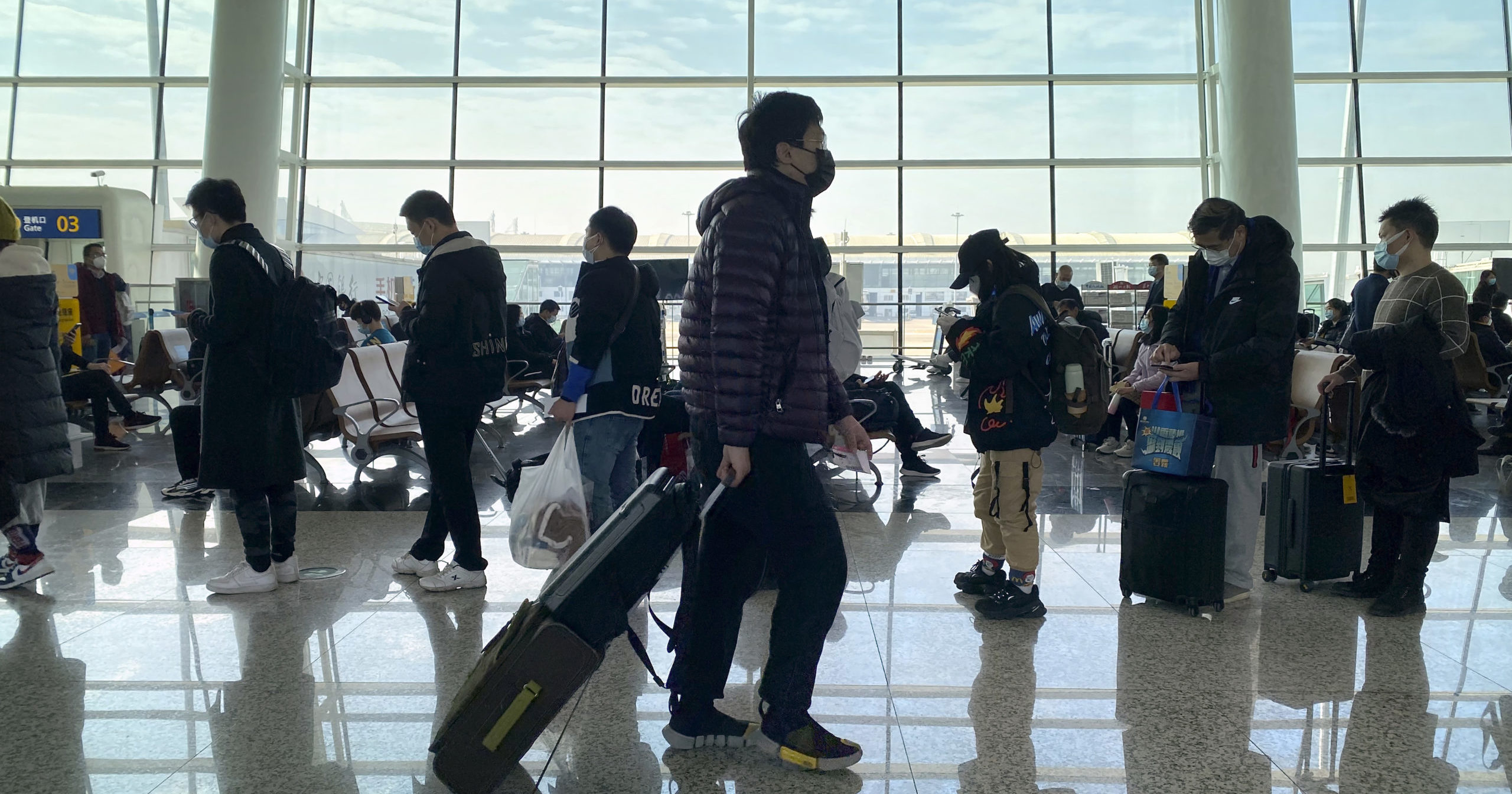 Passengers line up at a boarding gate at Wuhan Tianhe International Airport in Wuhan, China, on Jan. 14, 2021.