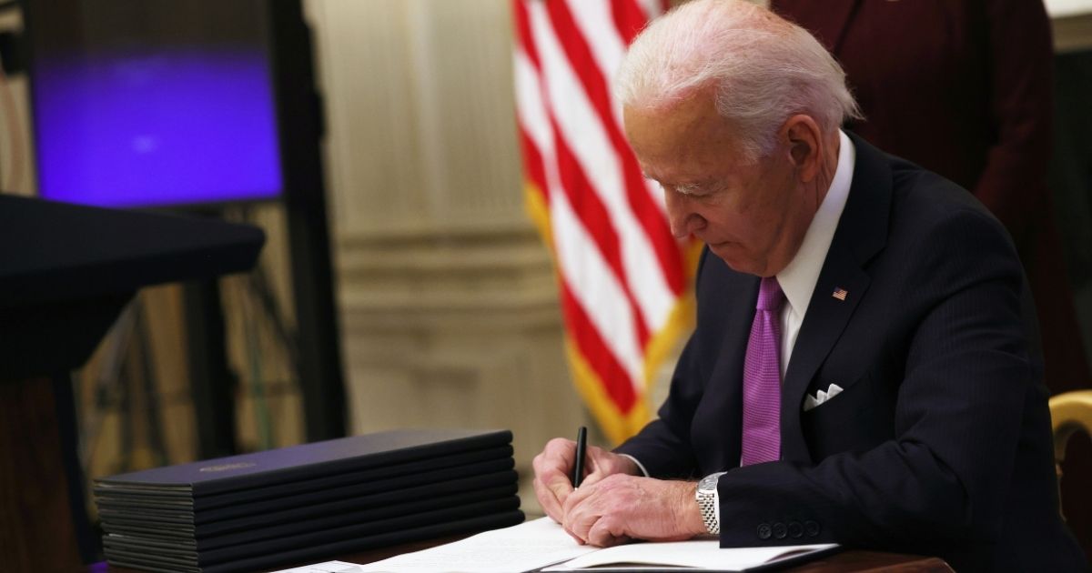 President Joe Biden signs an executive order in the State Dining Room of the White House on Jan. 21, 2021, in Washington, D.C.