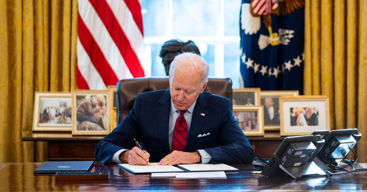 President Joe Biden signs executive orders in the Oval Office of the White House on Jan. 28, 2021, in Washington, D.C.