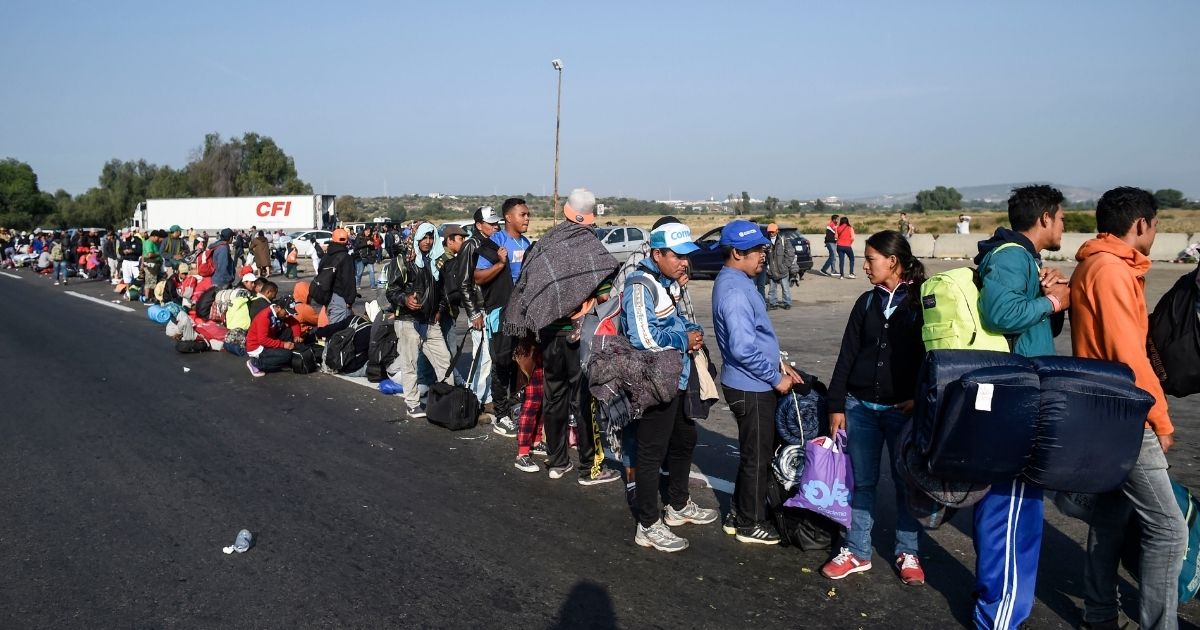 Central American migrants taking part in a caravan to the U.S. queue along the highway to get a ride to Irapuato in the state of Guanajuato on Nov. 11, 2018, after spending the night in Queretaro in central Mexico.