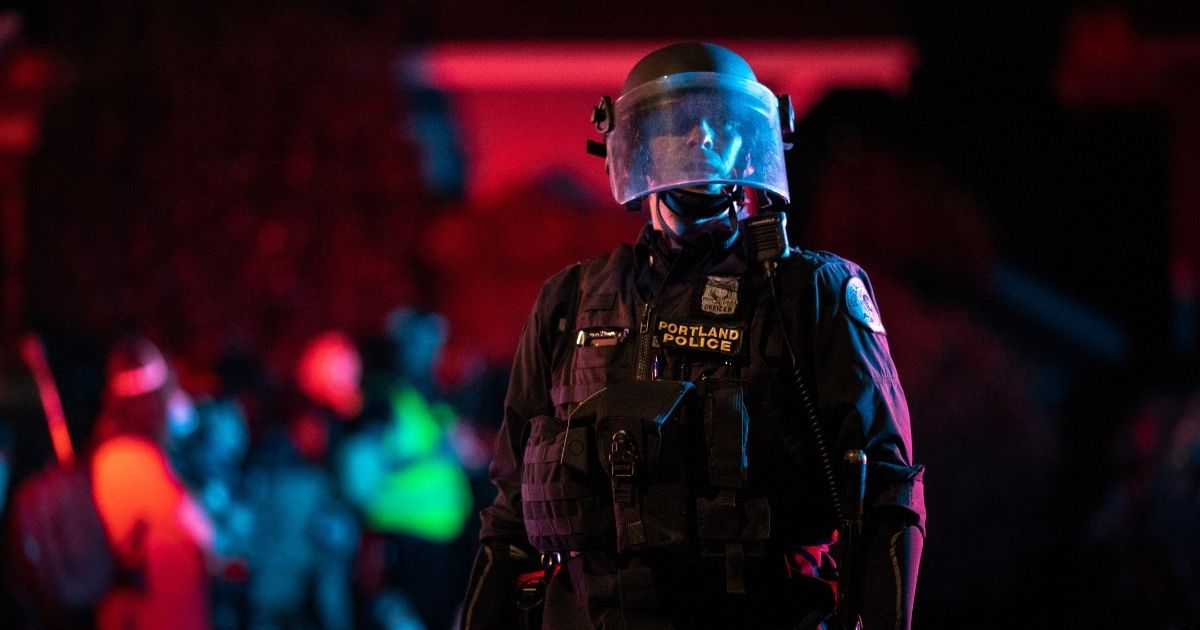 A Portland police officer is seen in riot gear during a standoff with protesters in Portland, Oregon, on Aug. 16, 2020.