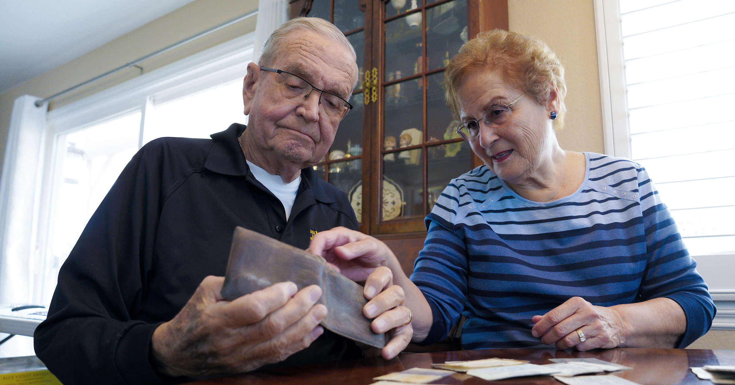 Paul Grisham and his wife Carole Salazar look over his wallet and the items that were inside when he lost it in Antarctica back in 1968 at their home in San Diego, California, on Feb. 3, 2021.