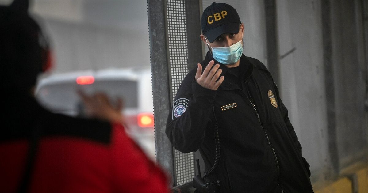 A woman shows identification to a U.S. Customs and Border Protection officer at the U.S.-Mexico border crossing in Matamoros, Mexico, on Tuesday.