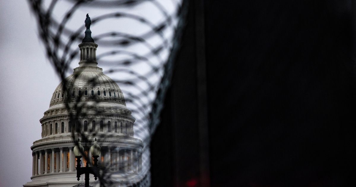 The U.S. Capitol dome is seen past security fencing and razor wire set up around Capitol Hill following the Jan. 6 Capitol incursion in Washington, D.C., on Thursday.