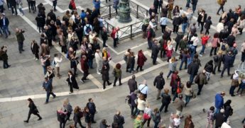 This stock photo shows a large crowd of people taking photos on a city street. Recent data has shown four states in the U.S. appear to have reached "herd immunity" from the coronavirus.